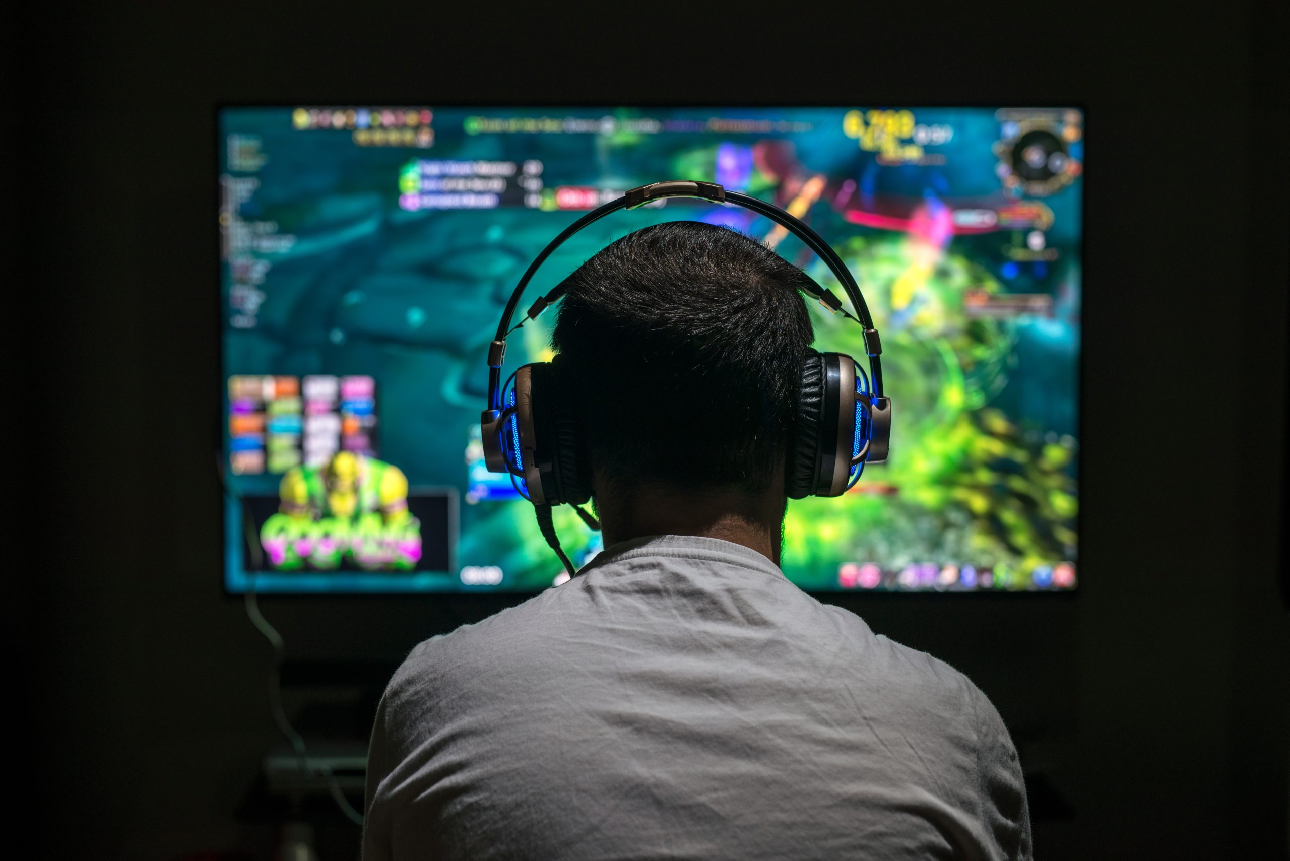 Young gamer playing video game wearing headphone.