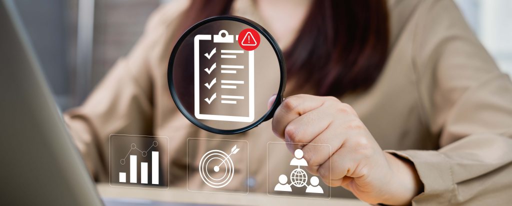 Image of a magnifying glass looking over a checklist of risks