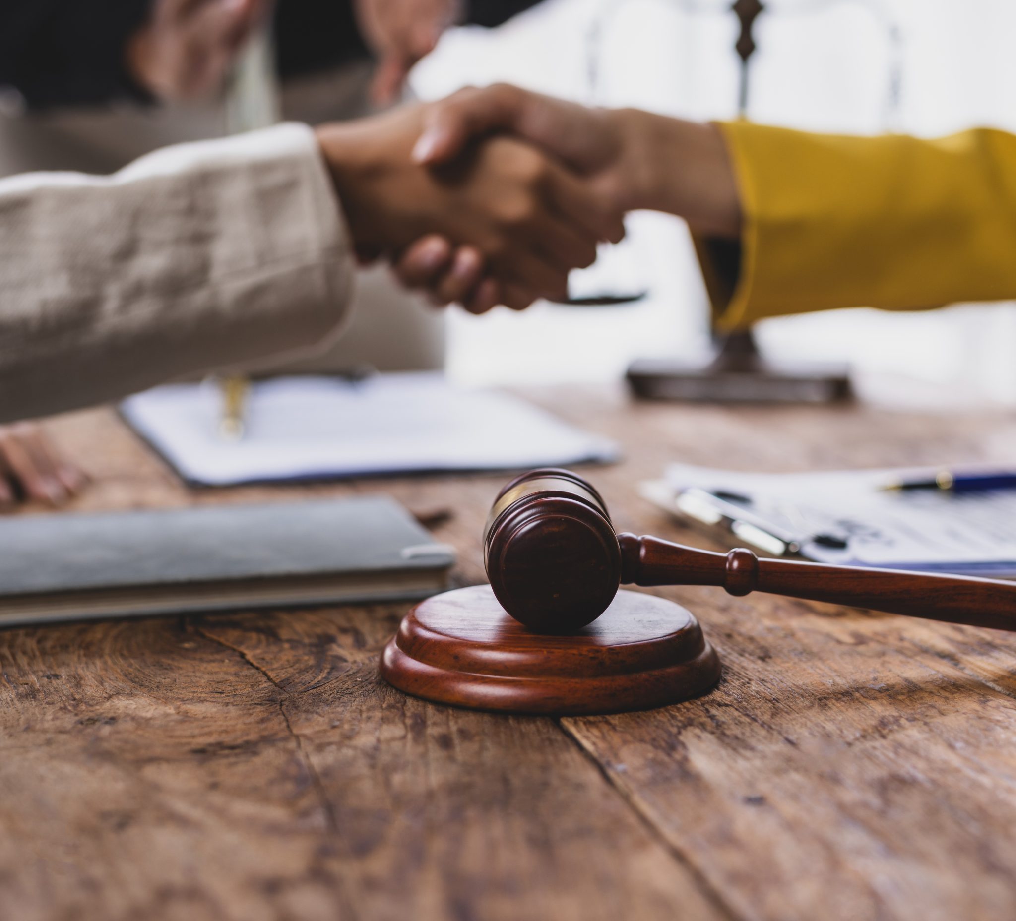 Two business professionals shake hands after tribunal decision.